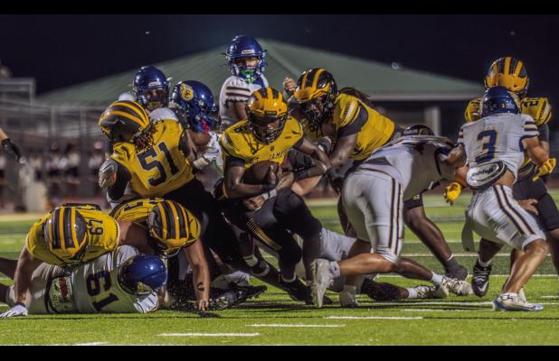 St. James ball carrier Xavier Johnson fights for yards last Thursday against St. Charles Catholic. Photo by Oliver Hooker
