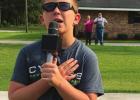 Nine-year old William Boyd proudly says the Pledge of Allegiance from his driveway last Friday in Convent as his grandparents observe in the background. Youngsters Step Up In Time Of Crisis