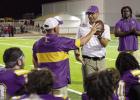 Lutcher Bulldog Associate head coach Chris Daigle presents head coach Dwain Jenkins with the game ball last Friday following Lutcher’s 51-8 victory over Assumption. With the win, Coach Jenkins picked up his 100th win as a head coach. Photo by Tony Schex