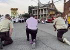 St. James Sheriff Claude Louis, Jr. and deputies kneel as the Monstrance approaches St. Michael Church. Photo by St. James Sheriff’s Office St. Micheal Church Shines As Host Of First Ever Féte Dieu Du Mississippi