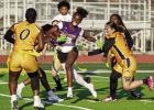 Lady Bulldog ball carrier Anias Johnson attempts to evade several St. James Wildcat defenders. The game was played on March 19th and the Bulldogs won 19-14. Photo by Tony Schexnayder
