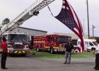 Members of the St. James Fire Department and Acadian Ambulance suspend a large American Flag on a ladder truck to commemorate the 25year anniversary of the September 11, 2001, terrorist attacks on the World Trade Center buildings in New York City, the Pen