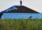 A roofer repairs a roof. Ida Tears Through And Tears Up St. James Parish