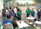 Salad Station owners Nick and Jessica Riley (green shirts toward right) say a few words to the crowd just before cutting the official ribbon to open the Town of Lutcher’s newest business. The Rileys said they wanted to not only bring a restaurant to the Salad Station Owners Proud & Excited To Offer Customers A Healthier Food Choice