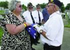 American Legion Post 171 member Donald Deroche presents Tommy Messina an American Flag and a grave marker in honor of her father, a WWII Veteran.
