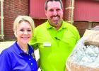 Chassity McComack from the Sheriff's Office receiving personal hand sanitizer bottles from Ken Cooley of Humana